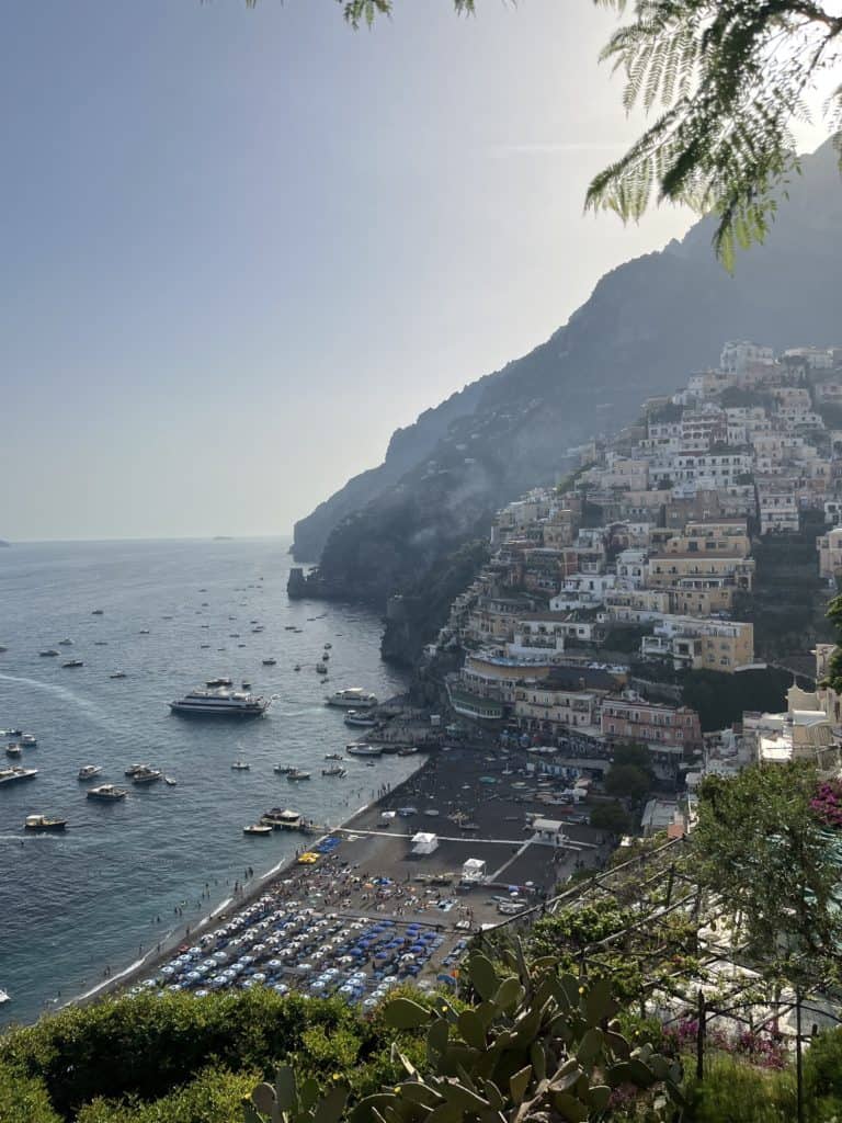 the famous beach area in Positano Italy with several pastel colored houses and villas located in the hills