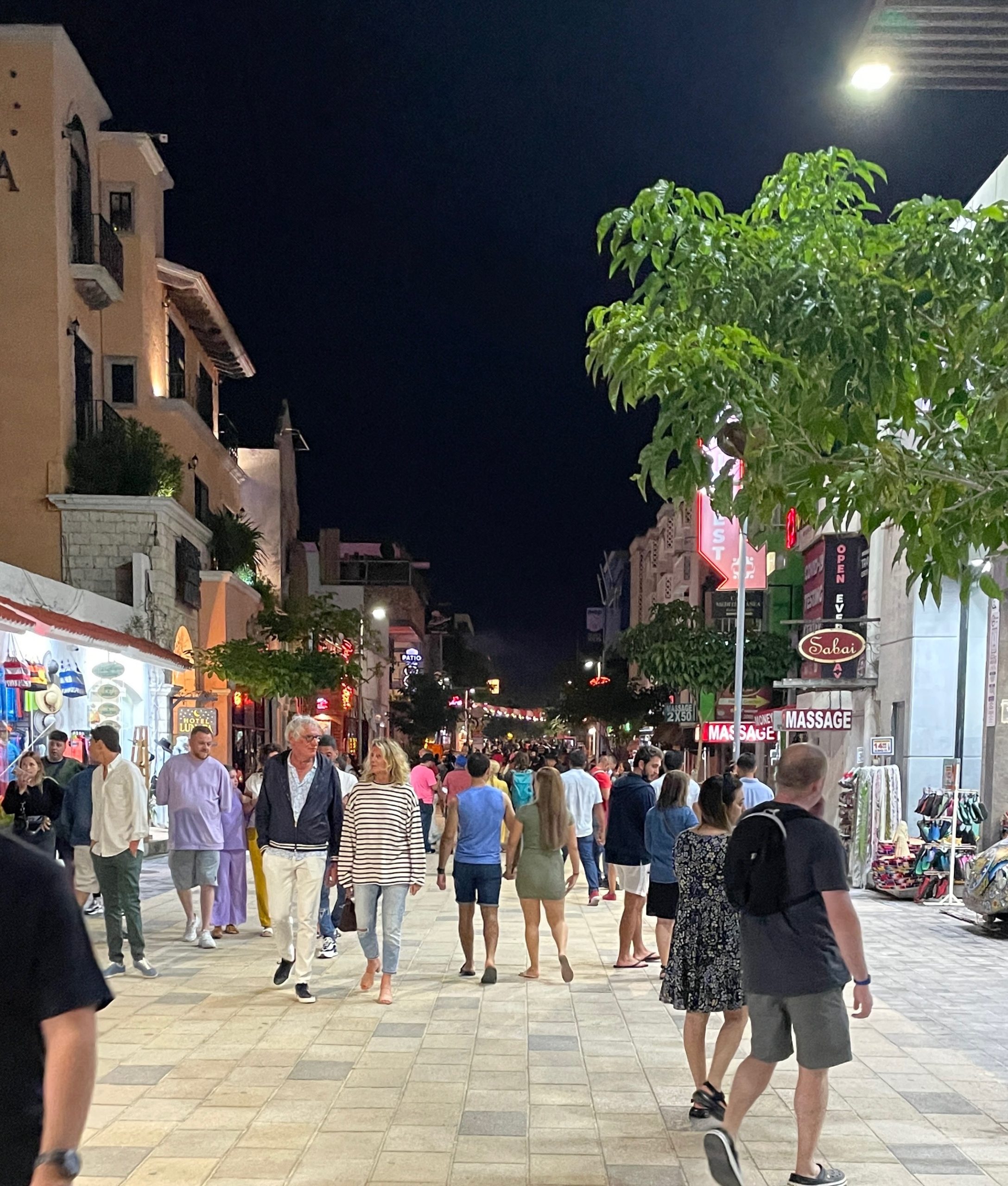 Crowds of tourists walking along Playa del Carmen’s vibrant 5th Avenue, lined with shops, restaurants, and lively street energy.