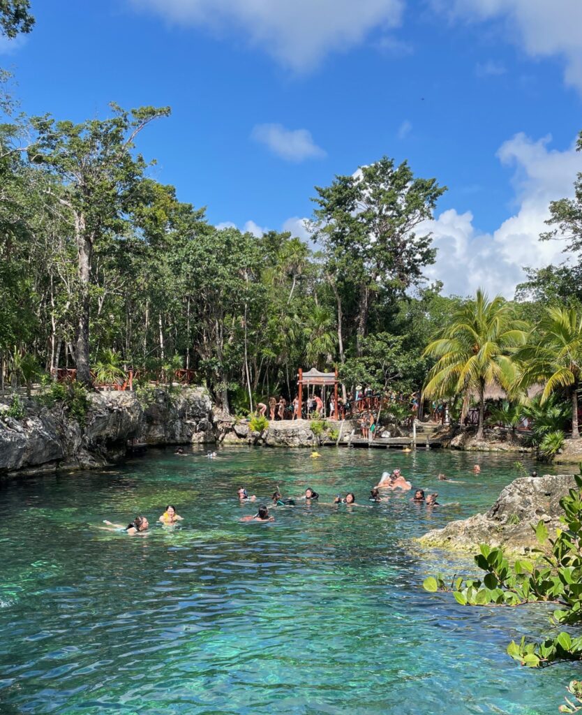 clear blue skies with clear water cenote in Tulum Mexico