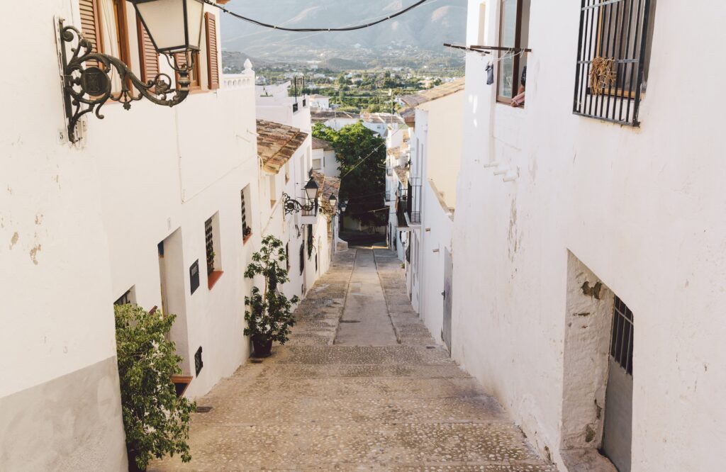 white coloured buildings within a pathway going downwards in the Old Town of Altea in Spain