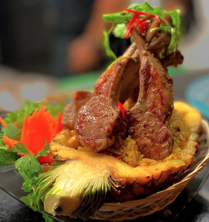 a large pineapple full of fried rice and meat at Curry Po Thai, a Thai restaurant in Tulum, Mexico