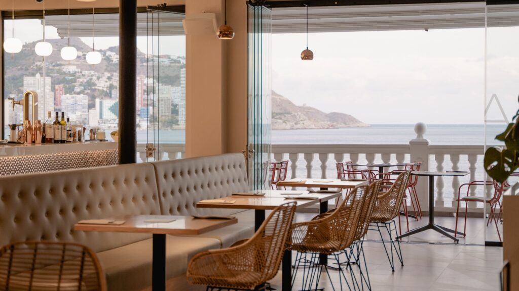 interior space at d vora restaurante with big glass windows showing the shoreline views of Benidorm Spain