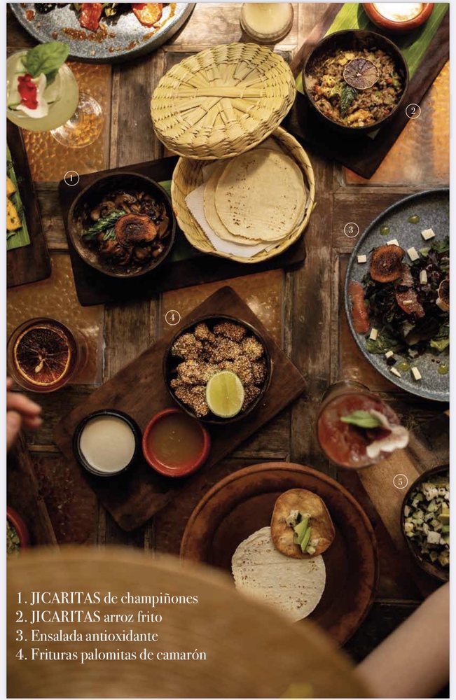 table full of various mexican style dishes at encanto cantina tulum