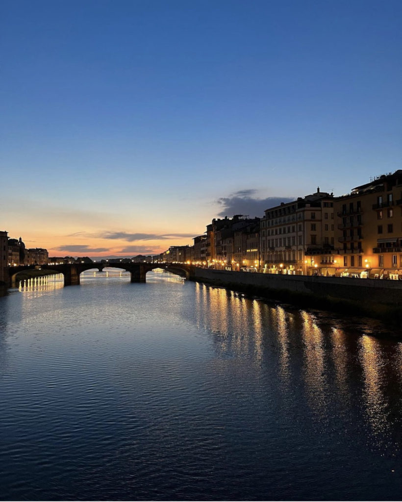 the sunset setting along the river full of bridges in along the water in Florence Italy