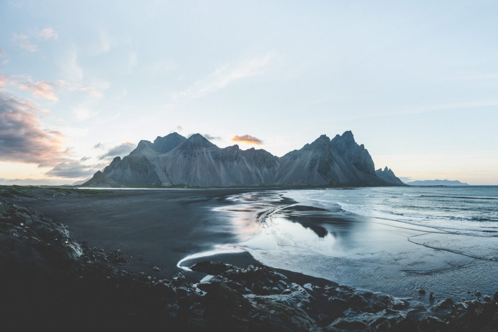 water with mountain views in the background and cloudy skies in Iceland