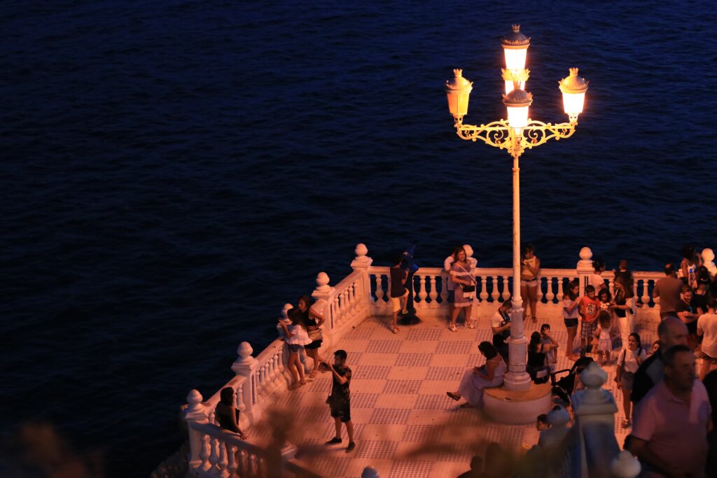 tourist taking photos at night at the famous Mediterranean balcony in Benidorm Spain