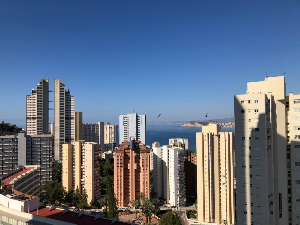 several skyscrapers along the seaside coastline with clear blue skies in Benidorm, Spain