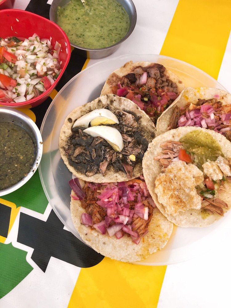 a table full of various types of tacos and salsa at Taqueria Honorio in Tulum, Mexico