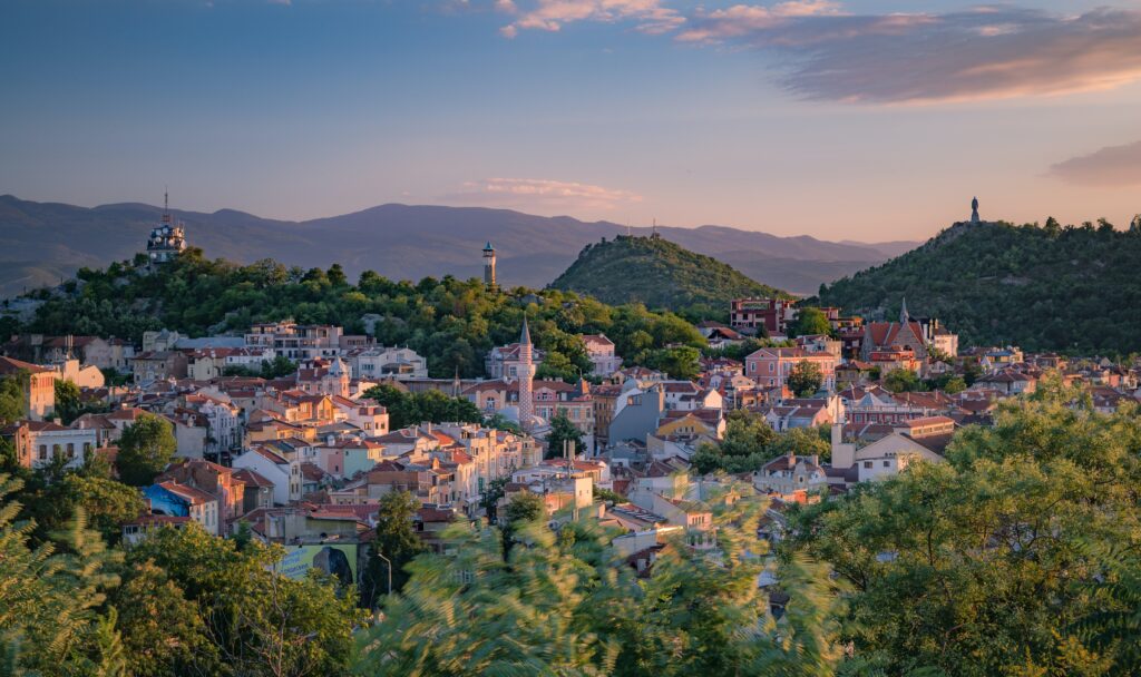 village town full of homes with rich green forests and mountains in the backgorund