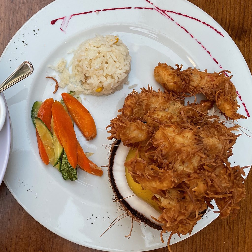 camarones al coco also known as coconut shrimp with a side of rice and veggies on a plate in playa del carmen mexico
