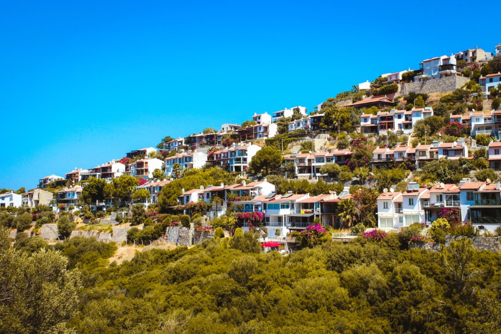 Several Mediterranean style homes sitting on a steeping hill along with clear skies in Bodrum Turkey 