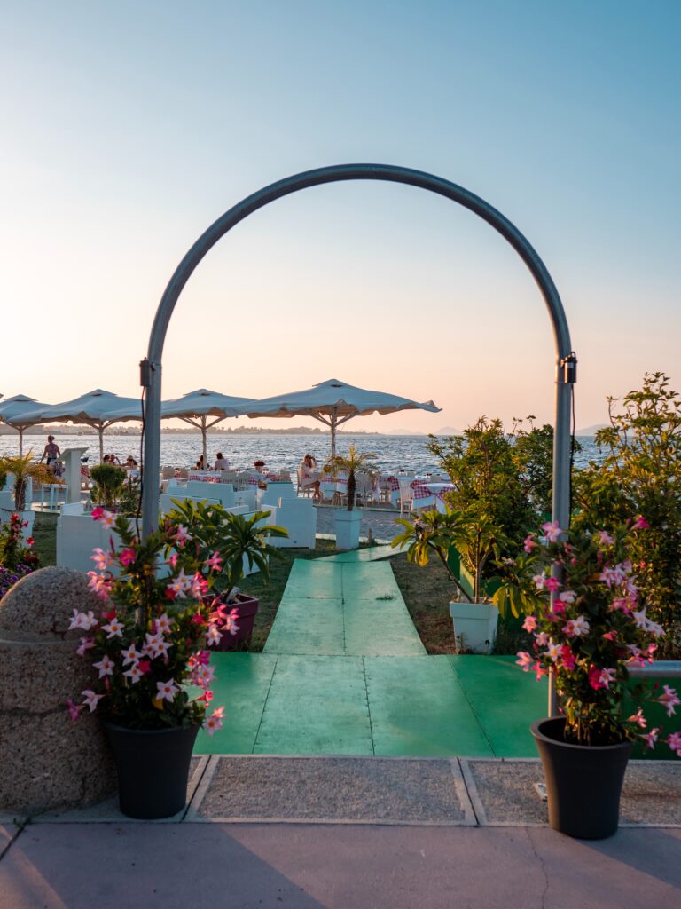 arches with walkway towards umbrellas along a beach shoreline in the island of Kos, Greece 