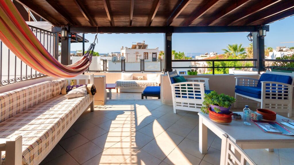 rooftop area at the La Luna hostel featuring a cozy rooftop with a chairs, table and a hammock in Bodrum