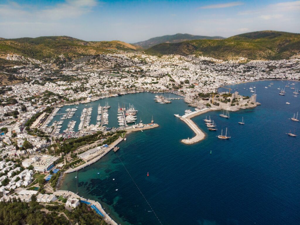 The main marina harbour with in Bodrum Turkey featuring several boats docked as well as mountains range in the background of the seaside town