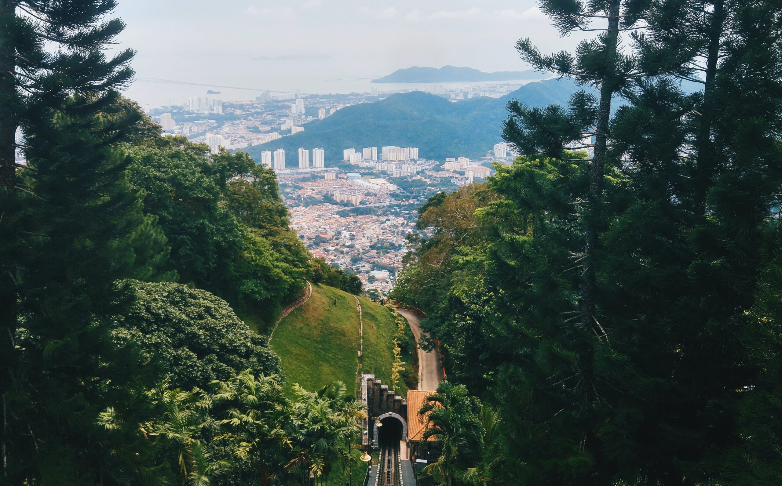 steep hill view from train tracks showing Penang city below sitting on extensive shorelines in malaysia