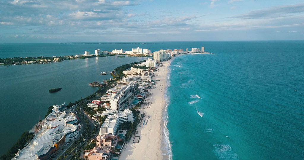 A long strip of hotels on a strip of land with the Caribbean sea on both sides in Cancun, Mexico