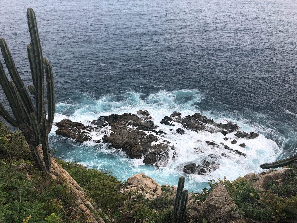 cliff showing aggressive blue waters below in Huatulco, Oaxaca 