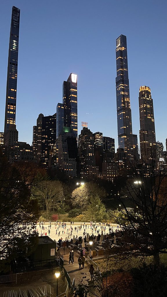 views of Wollman Rink and several skyscrapers on Billionaires row in Central Park New York