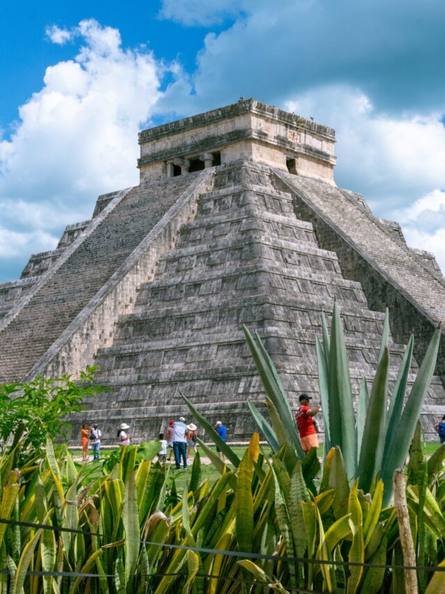 the famous chichen itza pyramid at the ruins along with clear blue skies