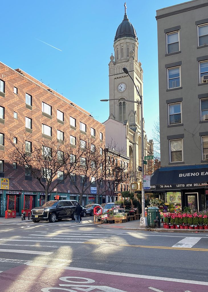 quiet street with a view of a small grocery store and church in the East Village, New York City