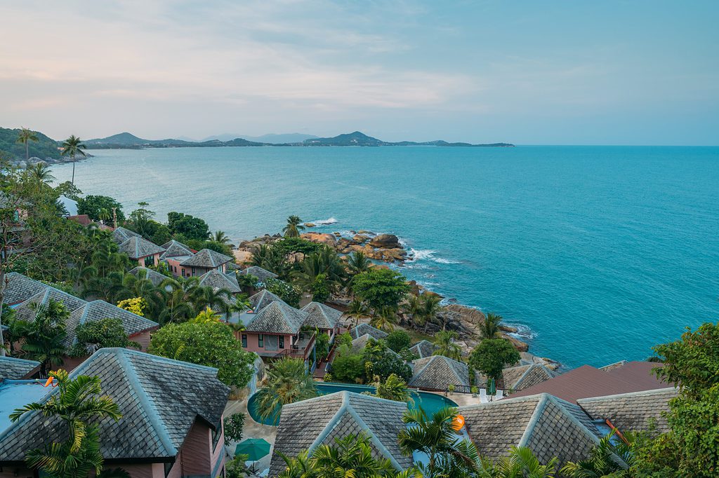 several houses sitting in the hills of Koh Samui island with stunning views of the ocean