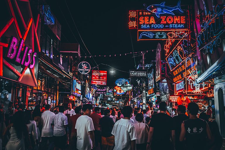 a crowd of tourists walking the nightlife streets of Pattaya City, Thailand