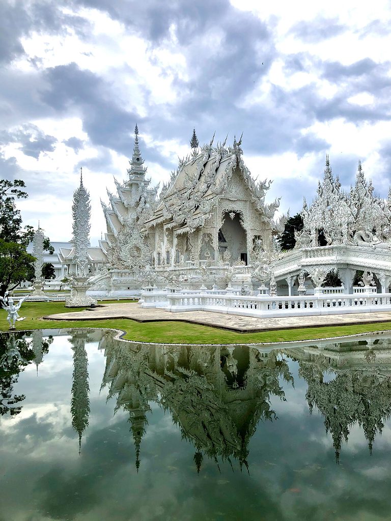 a photo of the famous White temple also known as Wat Rong Khun on a clear skies day in Chiang Rai, Thailand