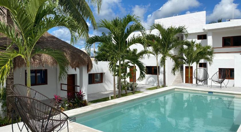 the beautiful pool with palm trees next to it at Xibalba in Town a Hostel in Bacalar, Mexico
