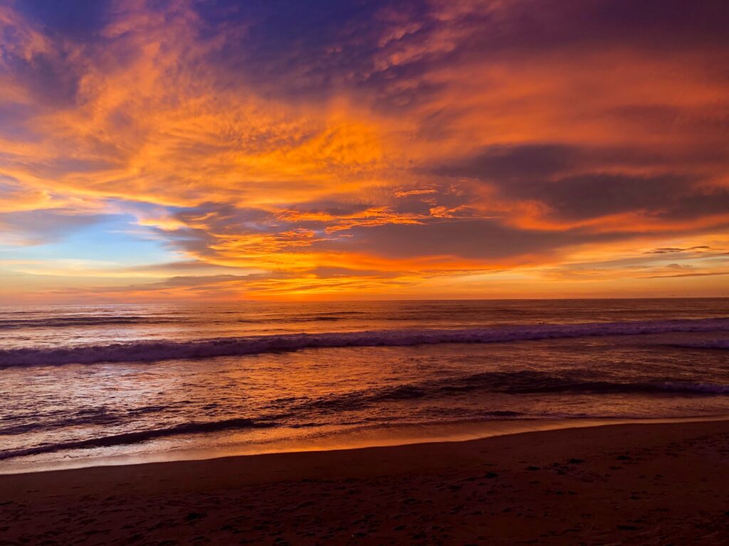 stunning colourful sunset with various shades of orange in the clouds at Bang Tao Beach in Phuket Thailand