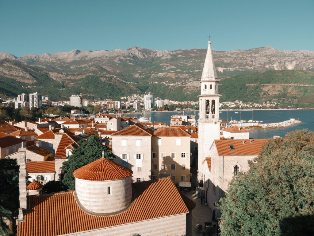 views of the old European style buildings along the sea and mountain views in the distance in Budva, Montenegro 