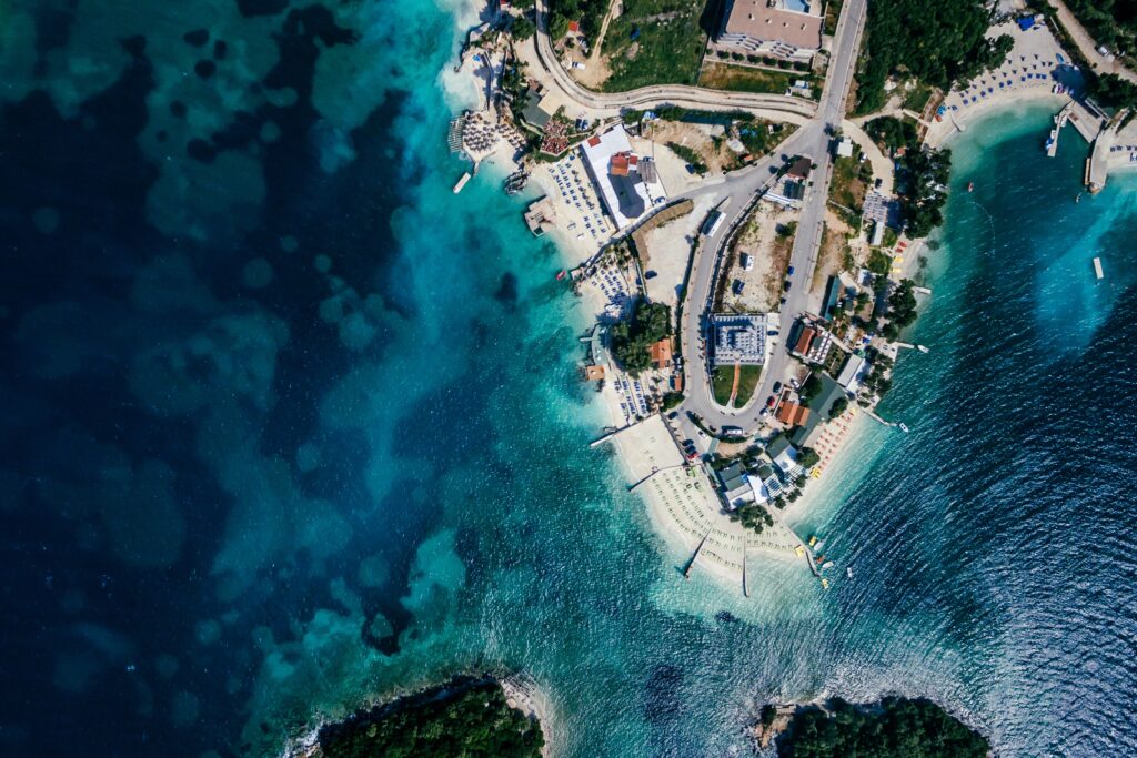 aerial view of Ksamil Island in Albania with various shades or turquoise waters surrounding it