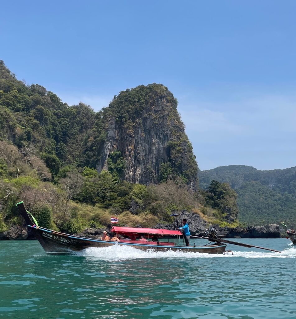a long tail boat taxi on the waters transporting passengers to Railay beach from Ao nang