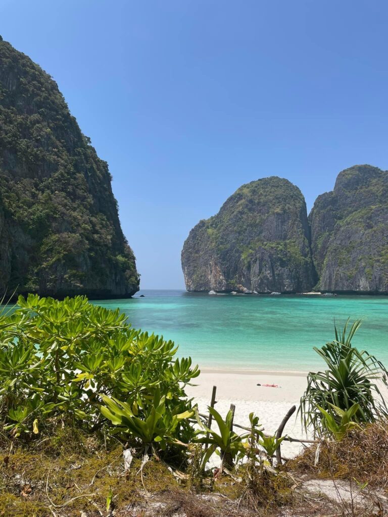 an empty beach with white sand and turquoise waters at the famous Maya Bay Beach in Thailand