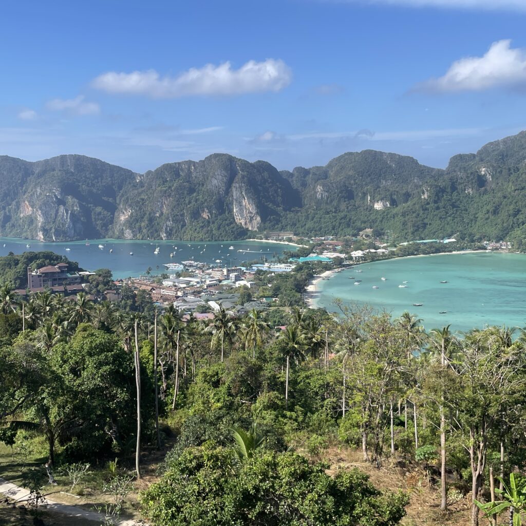 aerial view of the entire Phi Phi main Island showing clear skies, forest filled mountains and turquoise waters from each side of the island from Viewpoint 2