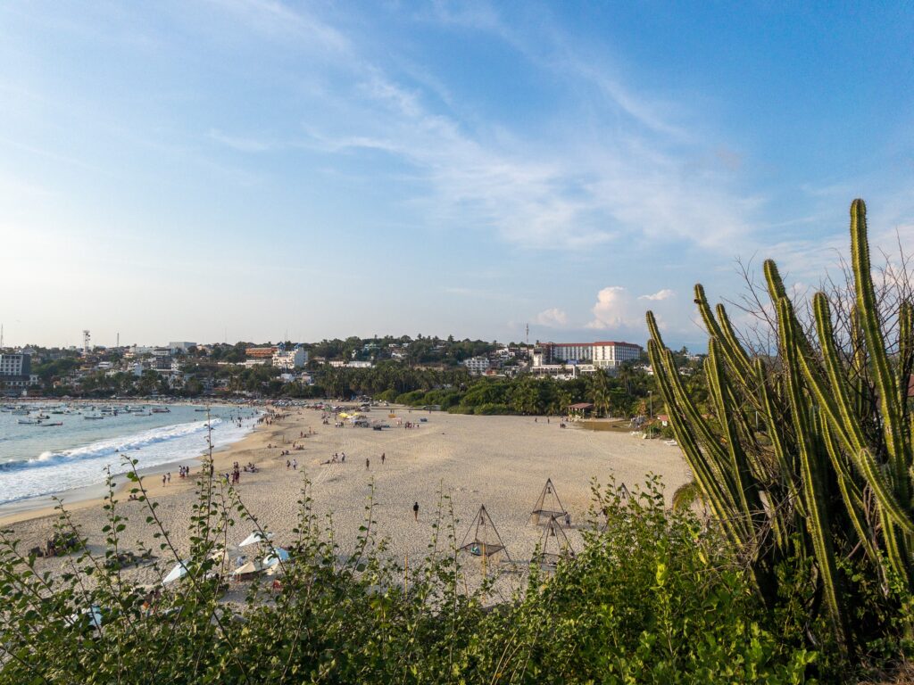 views of Playa Zicatela shoreline, featuring clear skies and waves crashing in Puerto Escondido