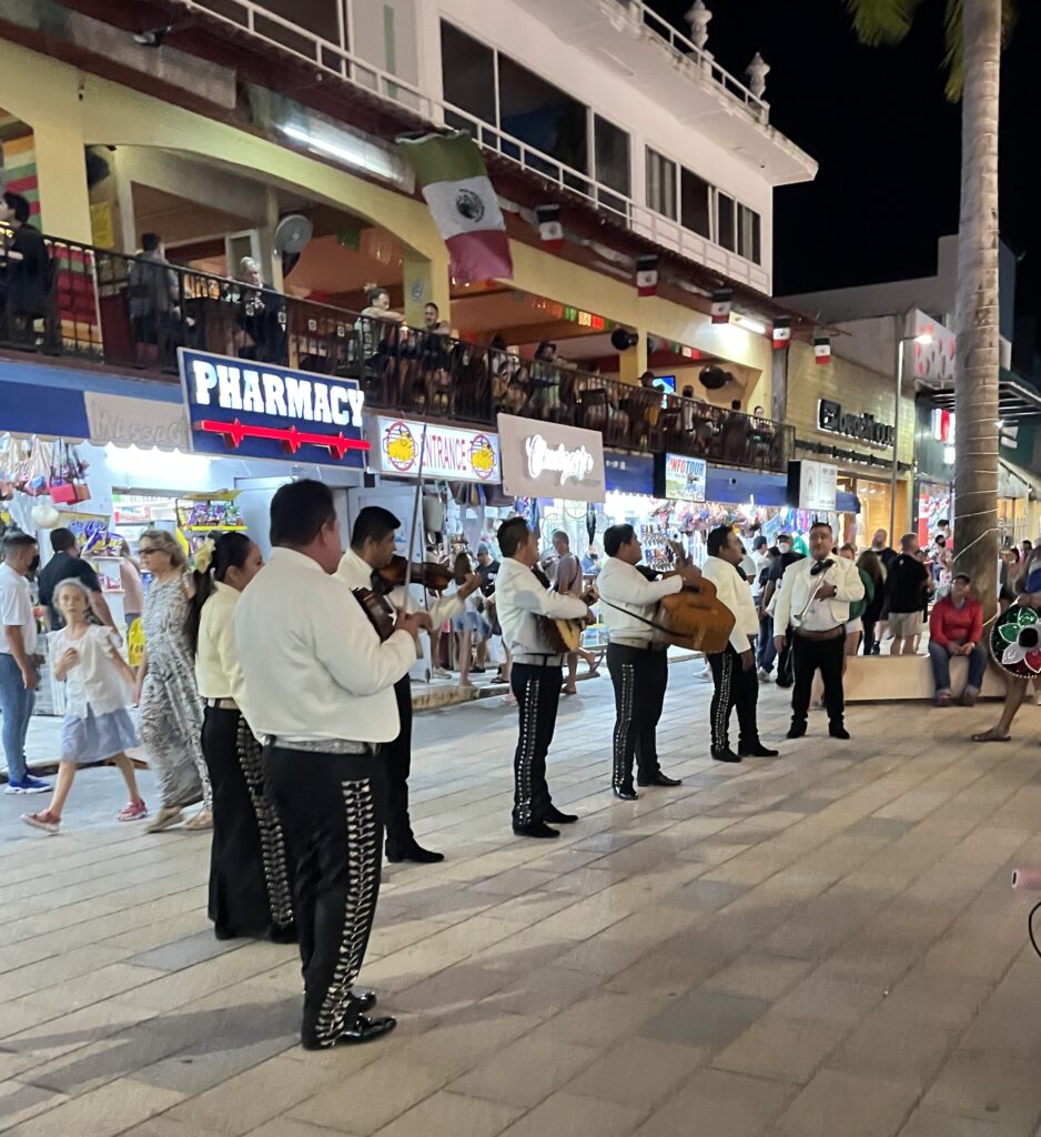 mariachi band performing for a crowd on 5th Avenue street in Playa del carmen