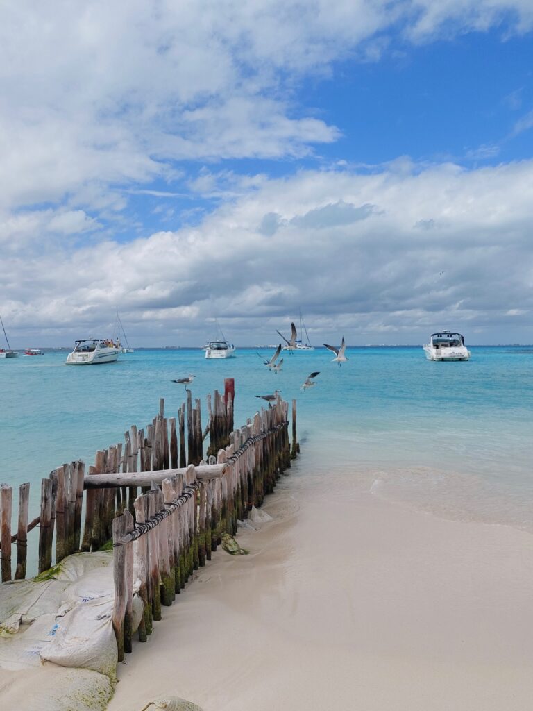 clear skies with various shades of turquoise blue waters at the beach in Isla Mujeres, Mexico