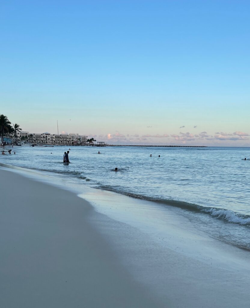 calm waters with a sunset beginning in the distance at Playa Del Carmen main beach