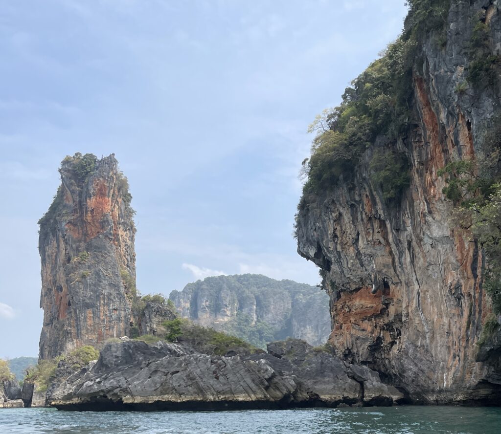 several large high rock formations of limestone along the water in Krabi, Thailand