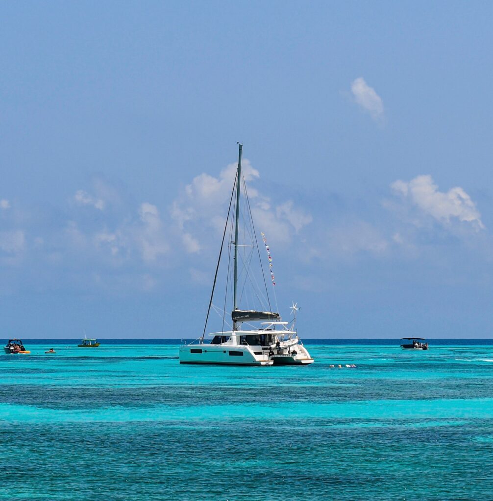 a sailboat rental sailing the stunning turquoise waters of Isla Mujeres on a clear sunny day