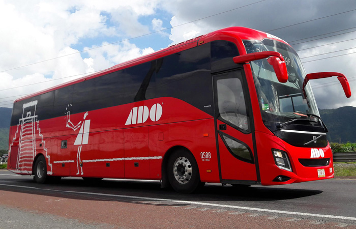 a large ADO Bus driving in the streets of Mexico