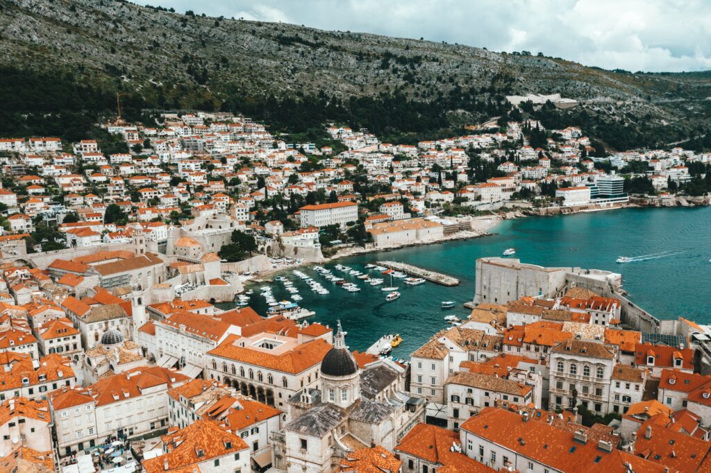 Aerial views of the seaside in Croatia with several red coloured houses along the seaside coast in Dubrovnik, Croatia