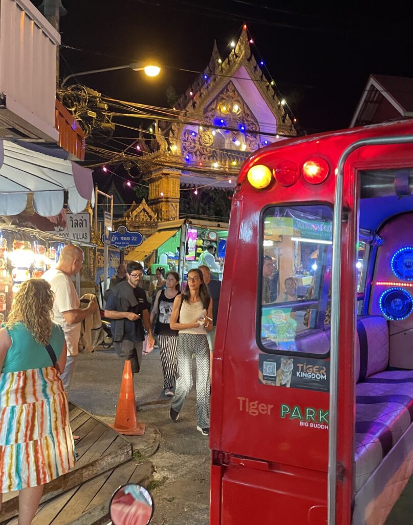 several tourists walking out and into the Karon Night Market in Karon Beach, Phuket, Thailand