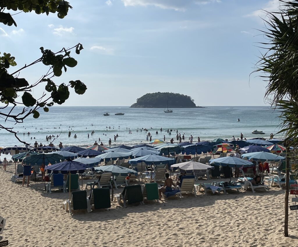 several beach lounge chairs and umbrellas lined up next to one another at Kata Beach in Phuket, Thailand / Things to do in Kata Beach