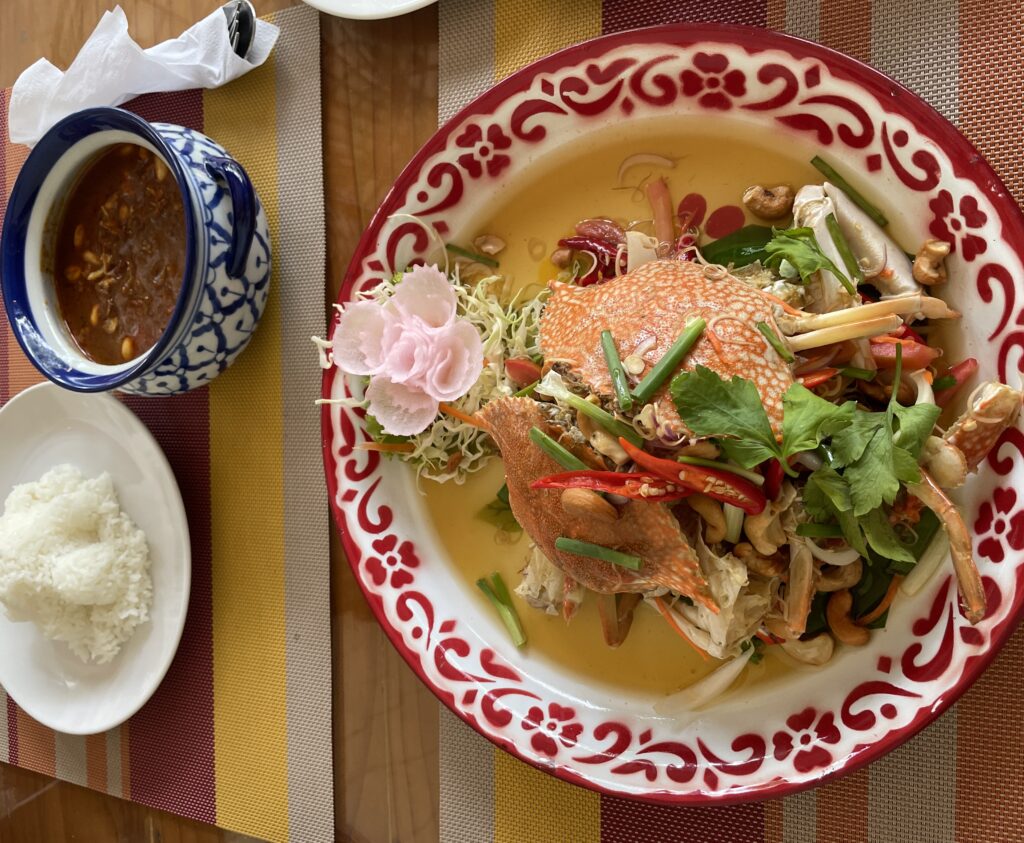 dungeness crab served on a cold lemongrass salad and massaman curry with rice being served at Pinto Karon, one of the best Karon Beach Restaurants