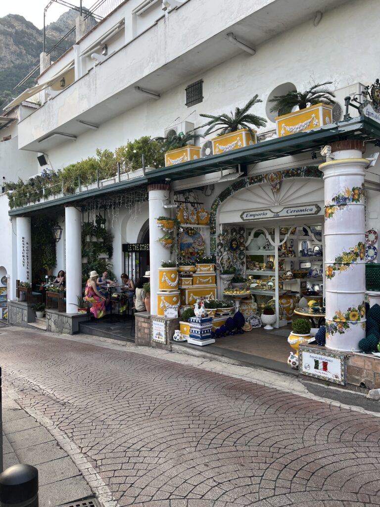 tourists eating at a local cafe with cobblestone walkways in Positano, Italy