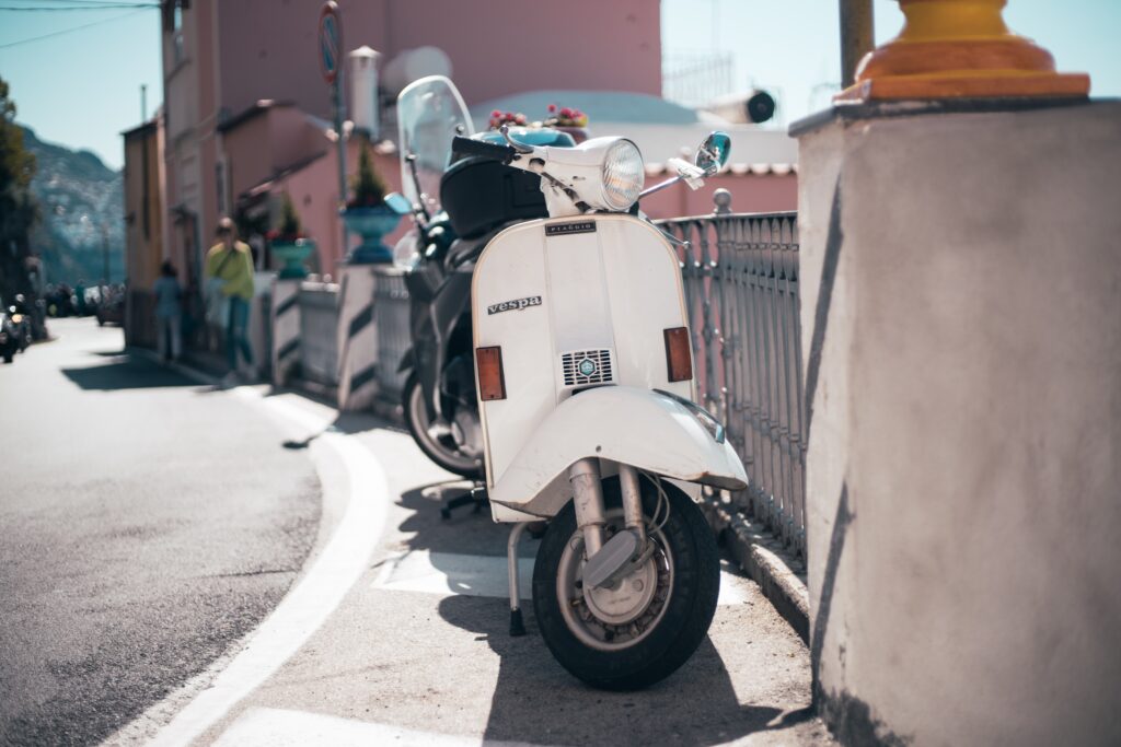 parked white vespa in the streets of Positano, Italy