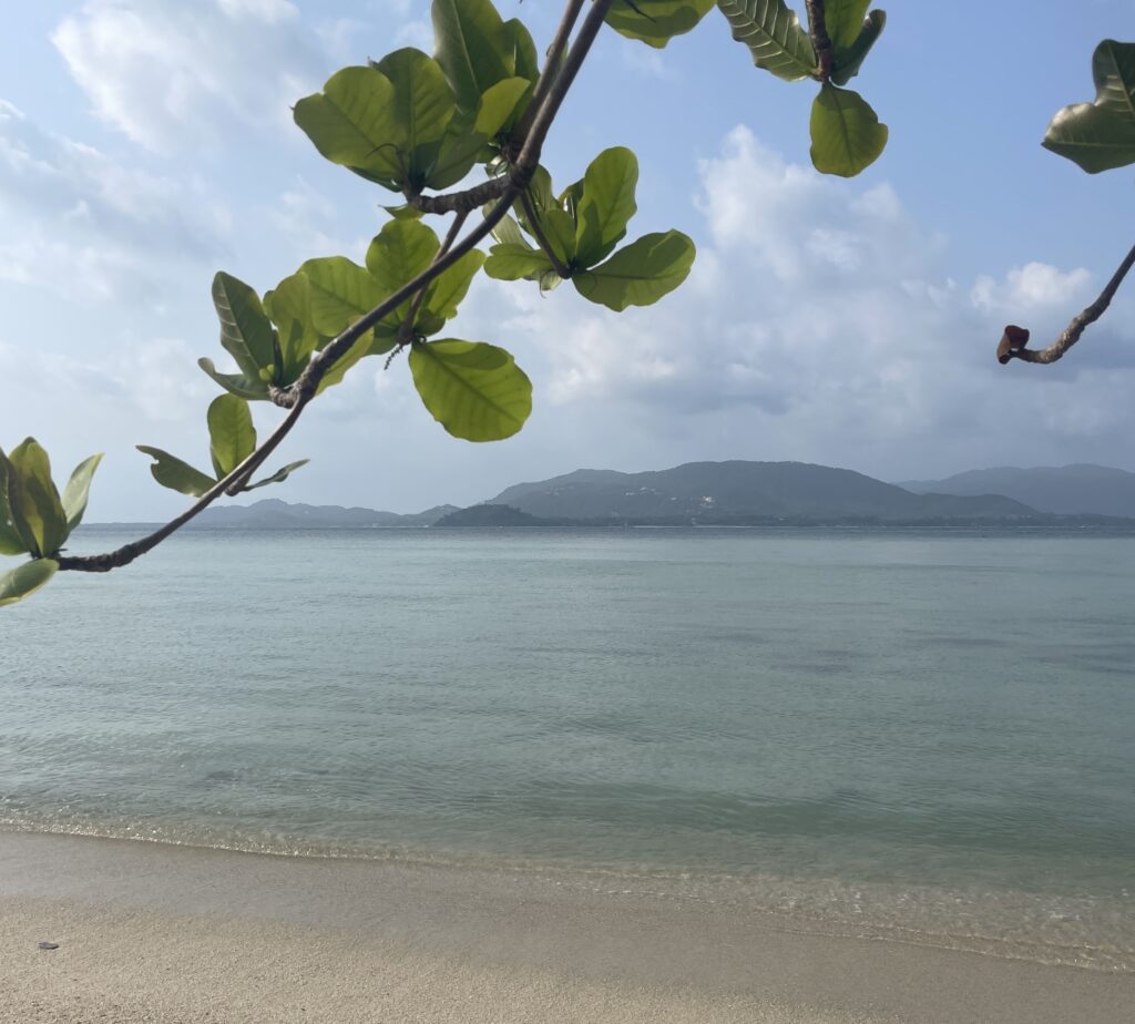 calm shallow beach with mountainous views in the distance Island in Samui District