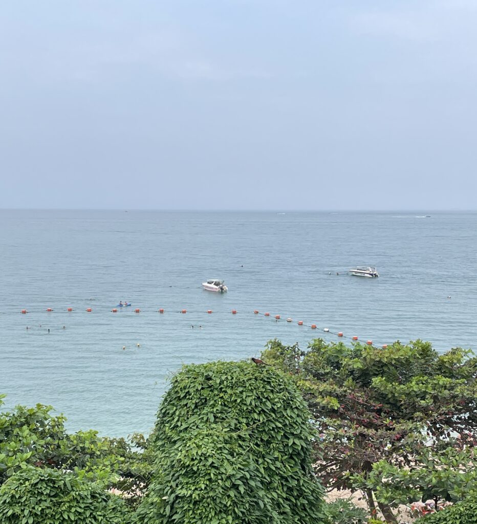 views of clear blue waters and boats passing by from a beach club in Pattaya City