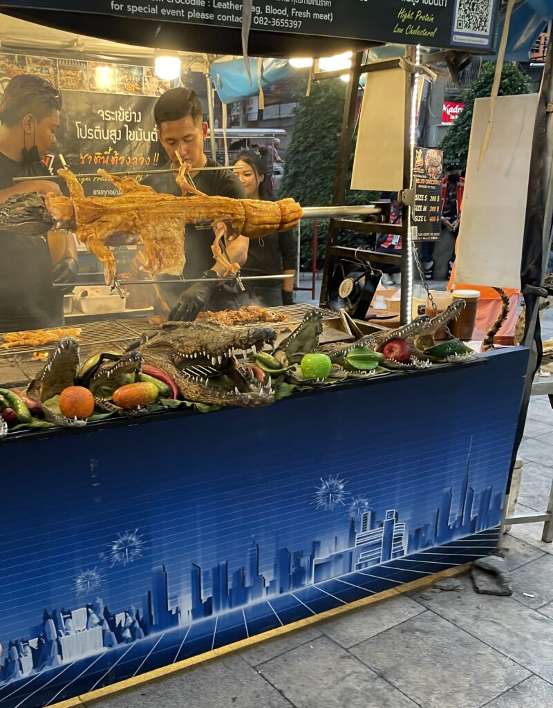 a full alligator being cooked on the street at a night market in Pattaya City